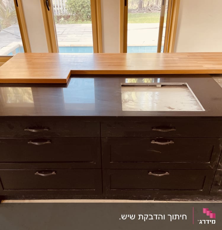 משטח שיש שחור עם חור מלבני במרכז